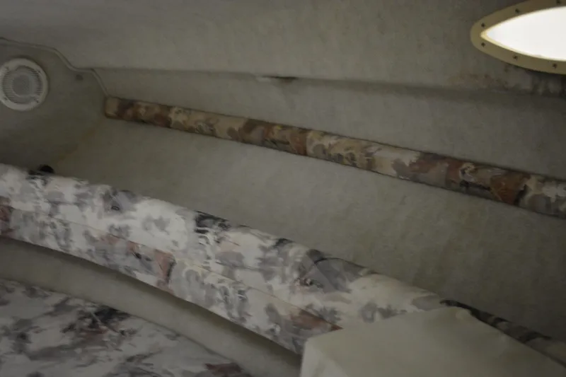 Slide: The Image of 1997 Sea Ray 240 Sundancer cabin interior with patterned seating and soft lighting. - 25
