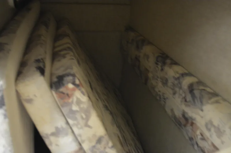 Slide: The Image of Interior cushions of a 1997 Sea Ray 240 Sundancer boat, featuring patterned upholstery. - 26