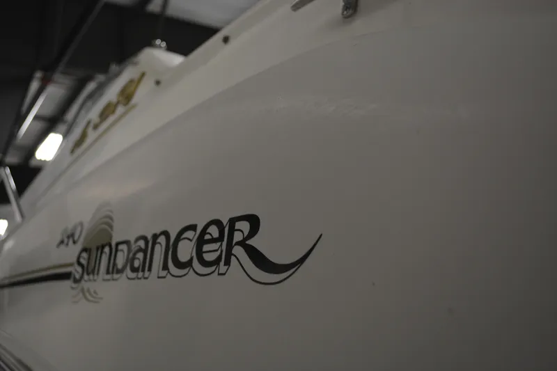 Slide: The Image of 1997 Sea Ray 240 Sundancer boat with logo detail in a dimly lit setting. - 5