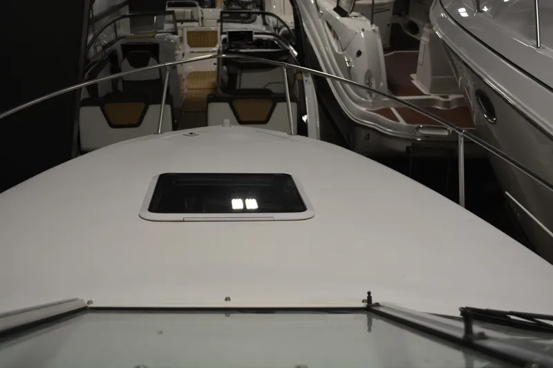 Slide: The Image of 1997 Sea Ray 240 Sundancer boat deck view in a showroom setting. - 7