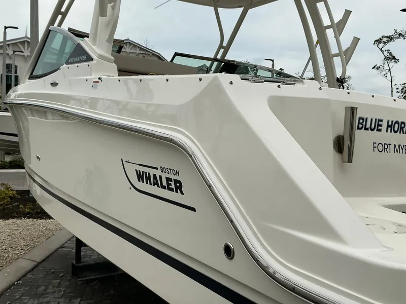 Slide: The Image of 2023 Boston Whaler 240 Vantage boat, side view, displayed outdoors. - 14