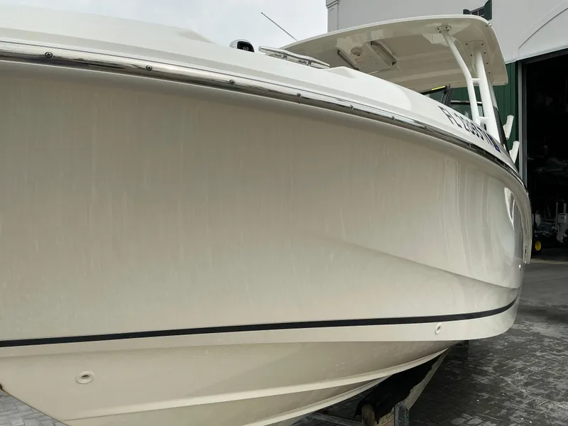 Slide: The Image of 2023 Boston Whaler 240 Vantage boat, side view, docked on a gray surface. - 2