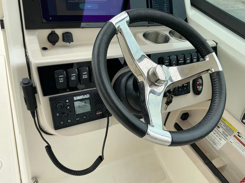 Slide: The Image of Steering wheel and controls of 2023 Boston Whaler 240 Vantage boat. - 21