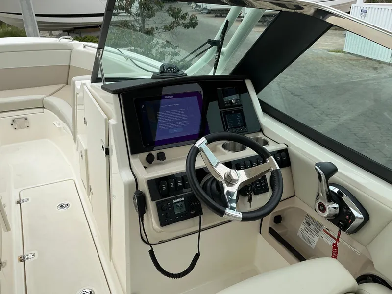 Slide: The Image of 2023 Boston Whaler 240 Vantage boat cockpit with steering wheel and control panel. - 23