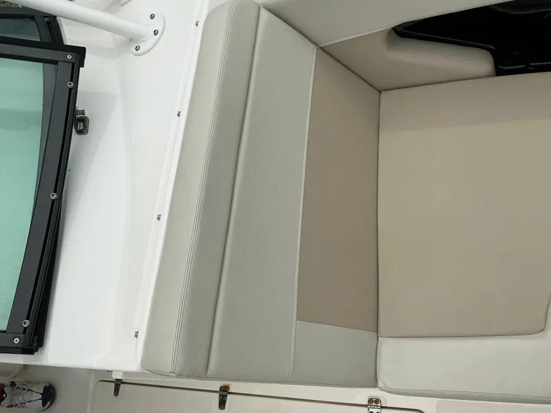 Slide: The Image of 2023 Boston Whaler 240 Vantage boat interior seating, featuring beige and gray upholstery. - 28