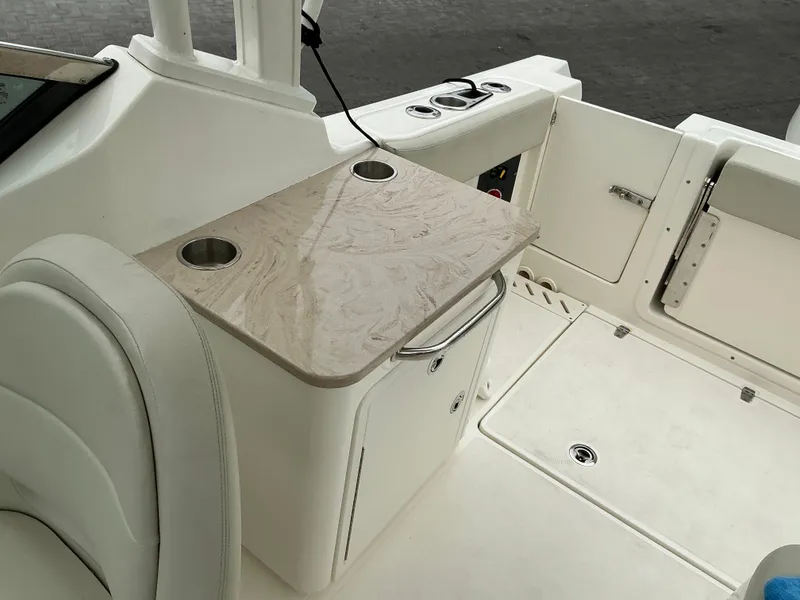 Slide: The Image of 2023 Boston Whaler 240 Vantage boat interior with beige countertop and cup holders. - 40