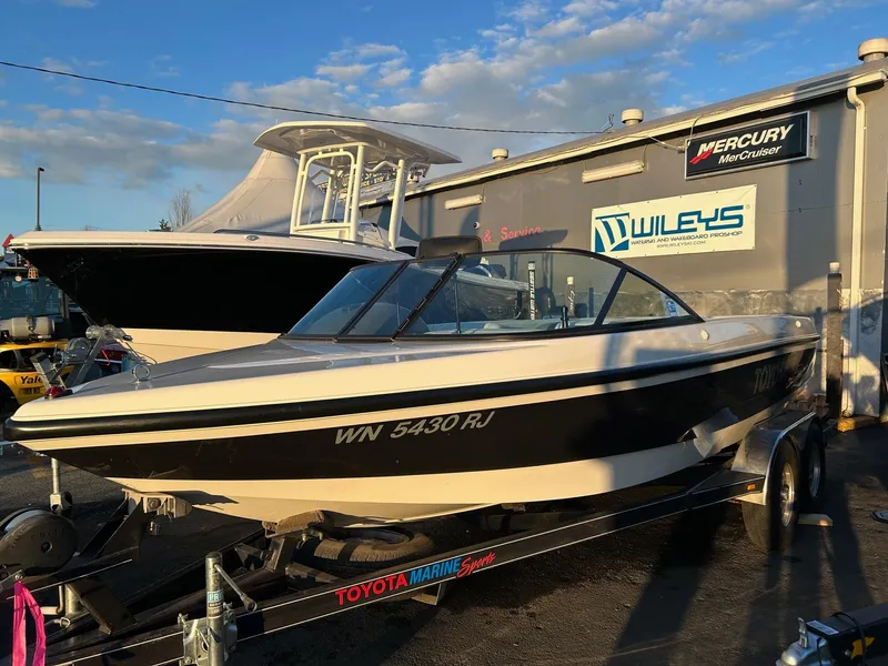 Slide: The Image of 1999 Toyota Epic 21 boat on trailer at dealership, sunny day, clear sky. - 2