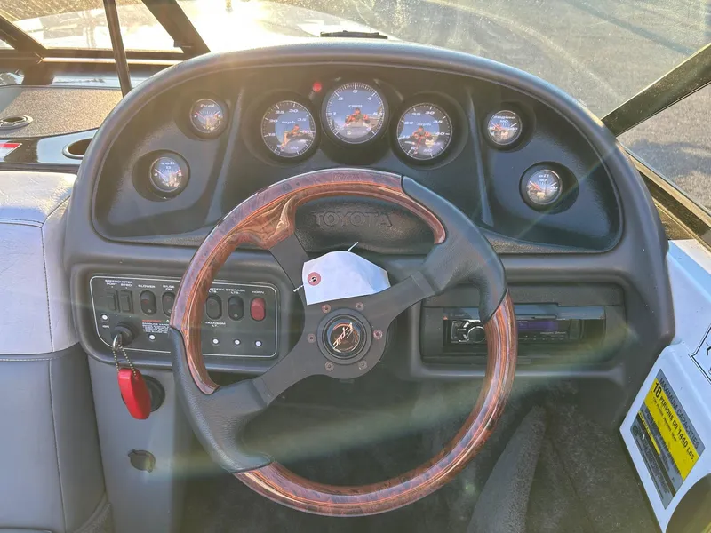 Slide: The Image of 1999 Toyota Epic 21 boat dashboard with wooden steering wheel and instrument gauges. - 5