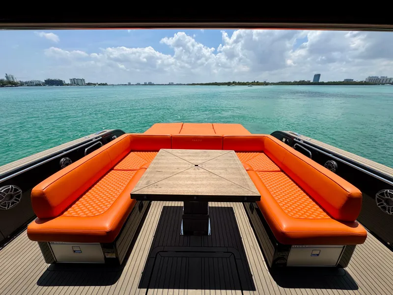 Slide: The Image of 2023 Pardo Yachts 50 with orange seating, wooden table, overlooking serene turquoise waters. - 8