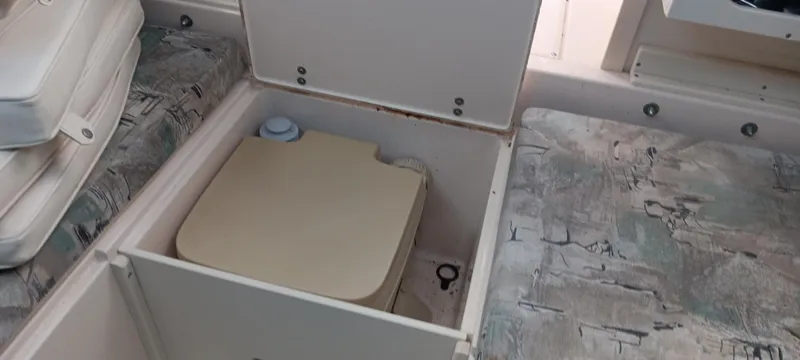 Slide: The Image of 1997 Grady-White Seafarer 226 boat interior with storage compartment and portable toilet. - 14