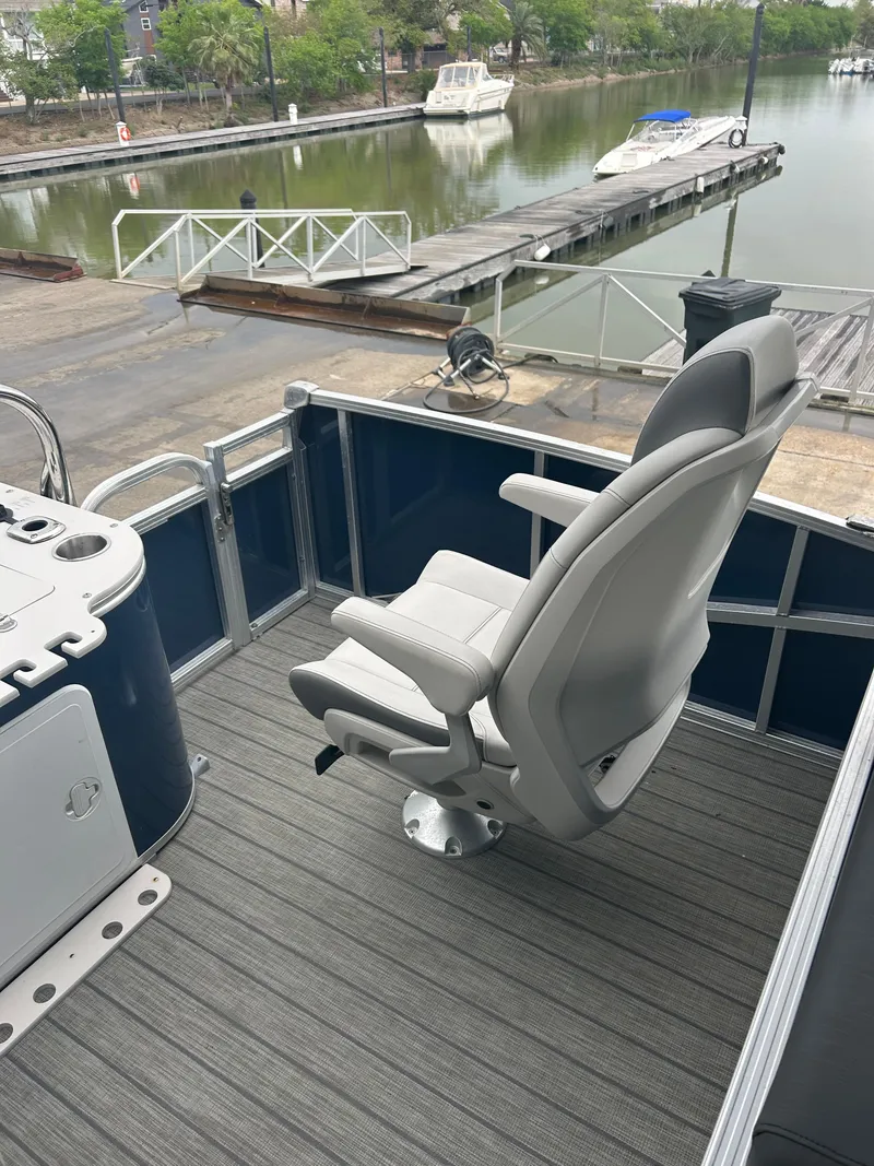 Slide: The Image of 2021 Avalon Catalina 24' boat with a comfortable captain's chair, docked by a serene waterfront. - 17