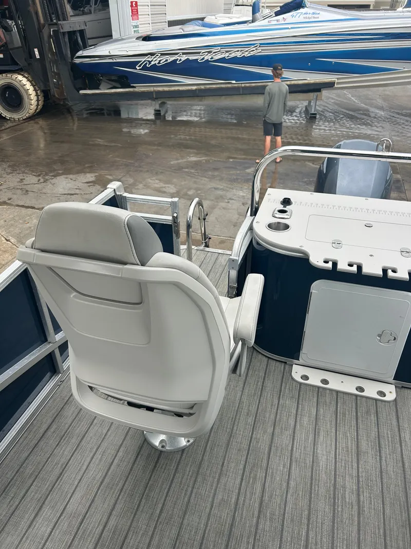 Slide: The Image of 2021 Avalon Catalina 24' boat interior with seating and control panel at a marina. - 18