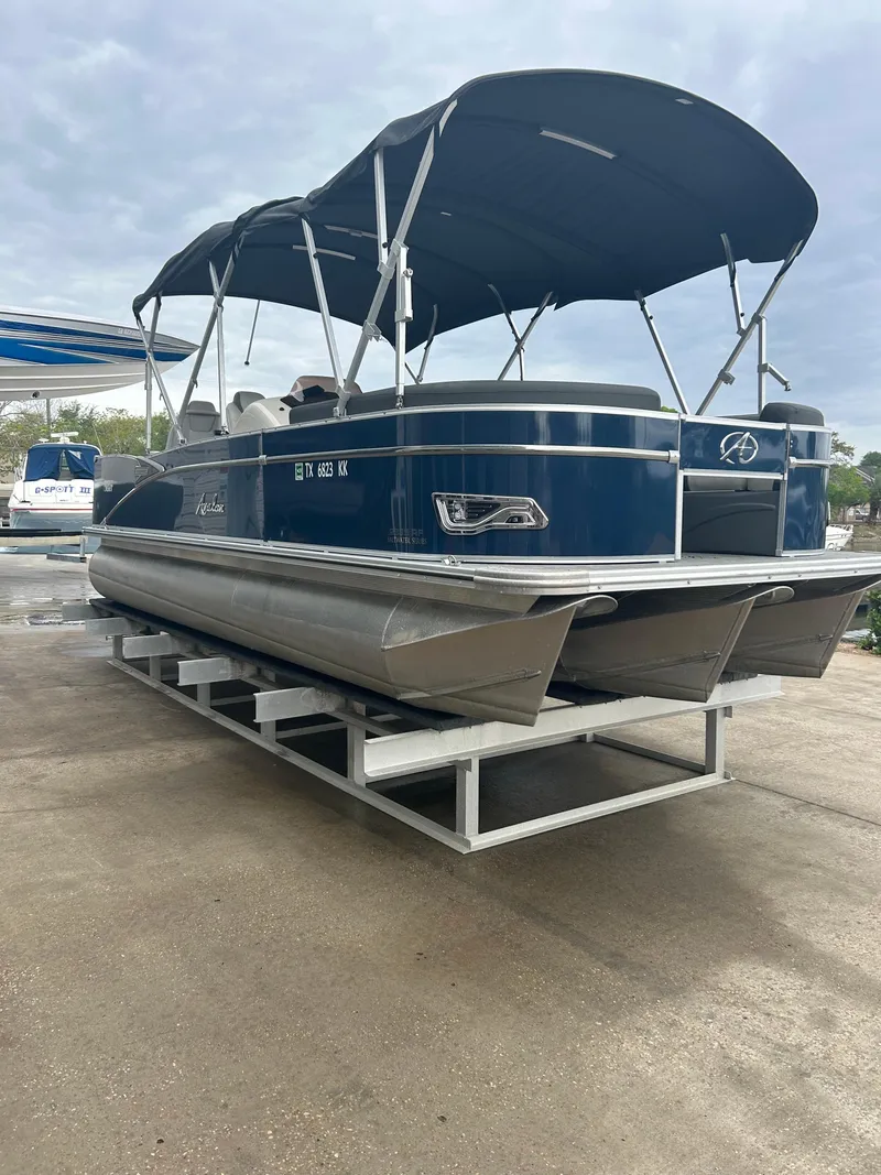 Slide: The Image of 2021 Avalon Catalina 24' pontoon boat with blue canopy on display. - 2