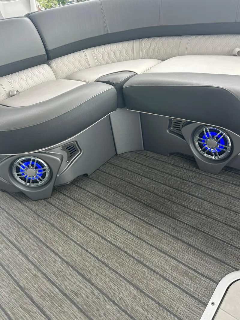 Slide: The Image of 2021 Avalon Catalina 24' boat interior with gray seating and blue-lit speakers. - 33