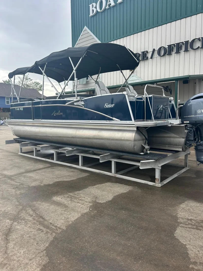 Slide: The Image of 2021 Avalon Catalina 24' pontoon boat with canopy, displayed outside a marine office. - 4