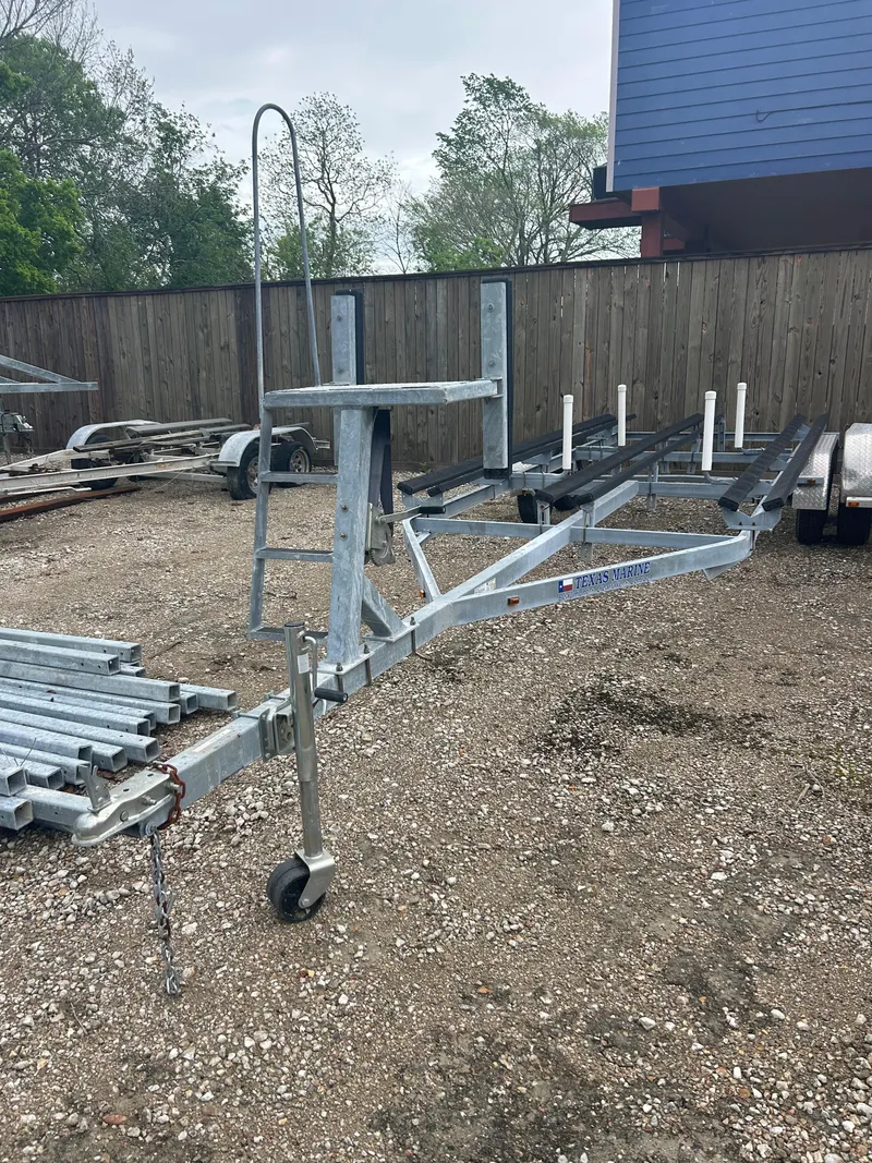 Slide: The Image of Boat trailer for Avalon Catalina 24', parked on gravel near a wooden fence. - 40