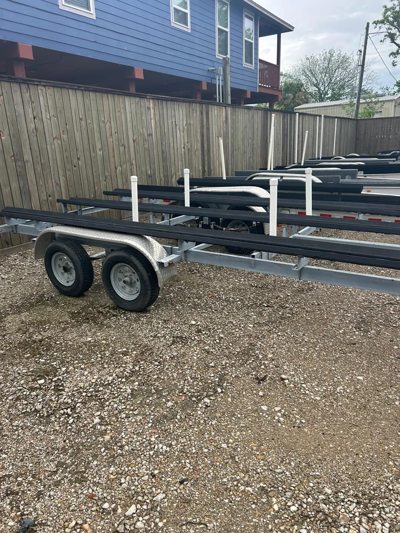 Slide: The Image of Trailer for 2021 Avalon Catalina 24' boat, parked on gravel near wooden fence. - 41
