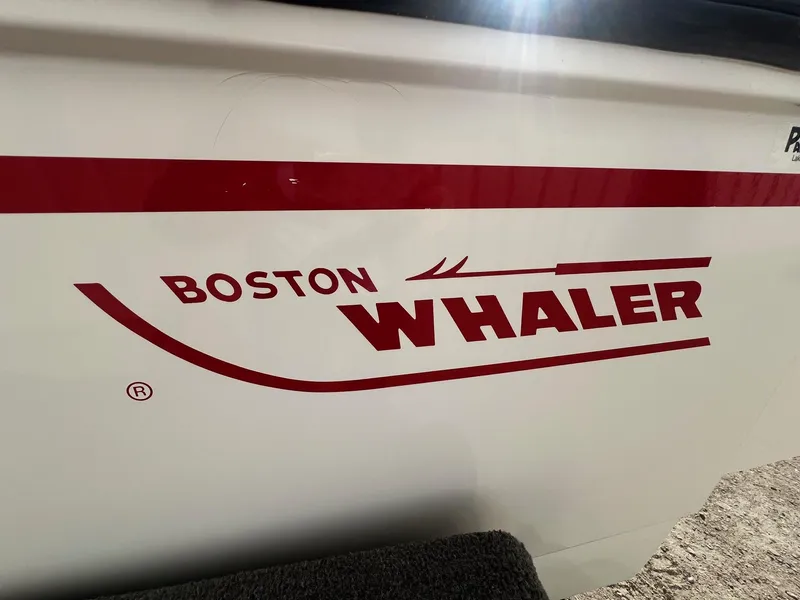 Slide: The Image of Boston Whaler 170 Dauntless 1995 boat logo on white hull with red lettering. - 2