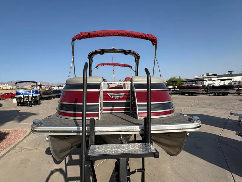Slide: The Image of 2021 Bennington 25 QSBA IO pontoon boat with red canopy, docked on a sunny day. - 1