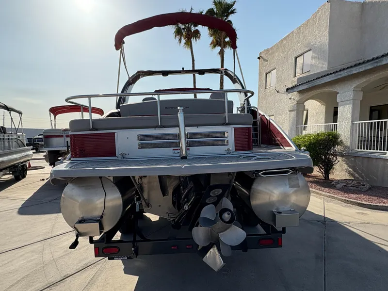 Slide: The Image of 2021 Bennington 25 QSBA IO pontoon boat, rear view, parked on concrete driveway. - 4