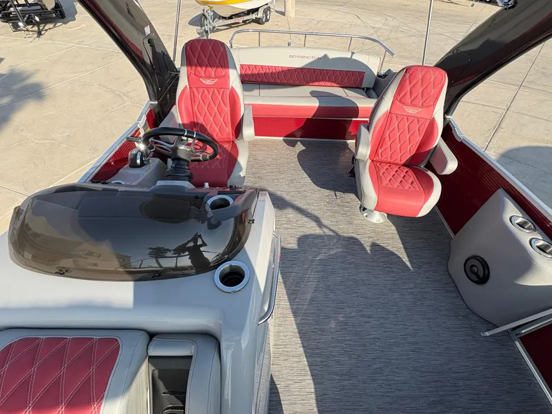 Slide: The Image of 2021 Bennington 25 QSBA IO boat interior with red and gray seating and steering console. - 6