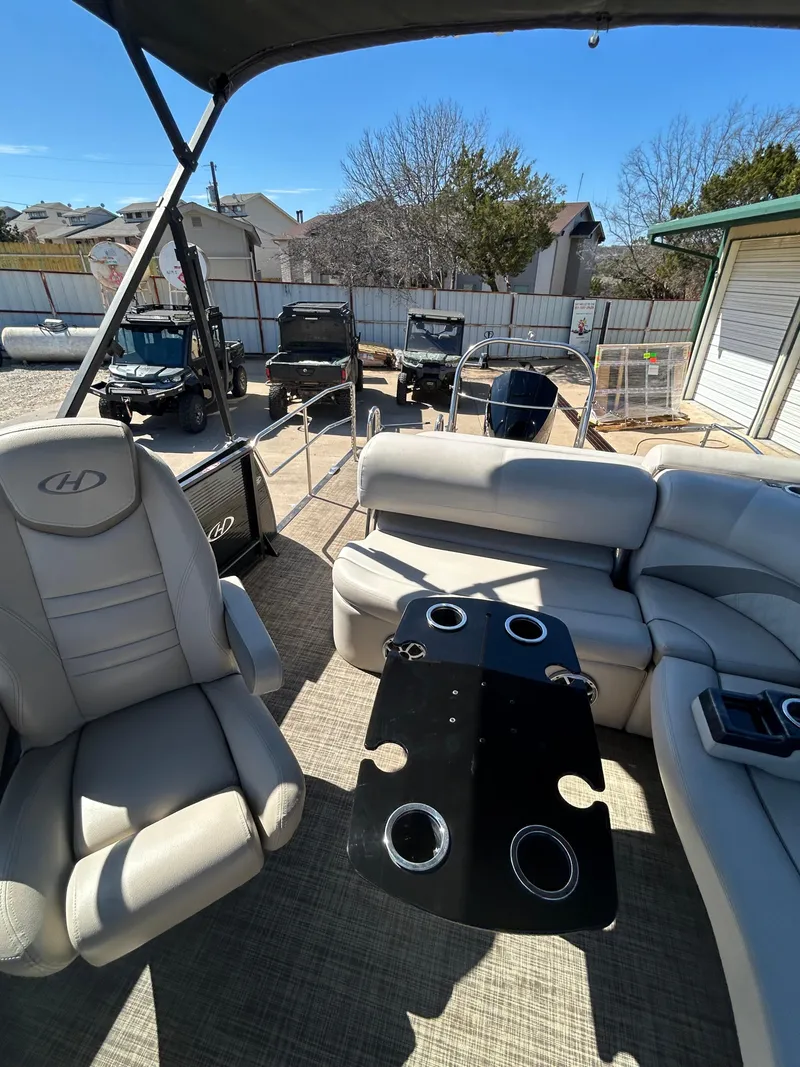 Slide: The Image of 2019 Harris Sunliner 240 interior with seating and table, parked outdoors. - 13