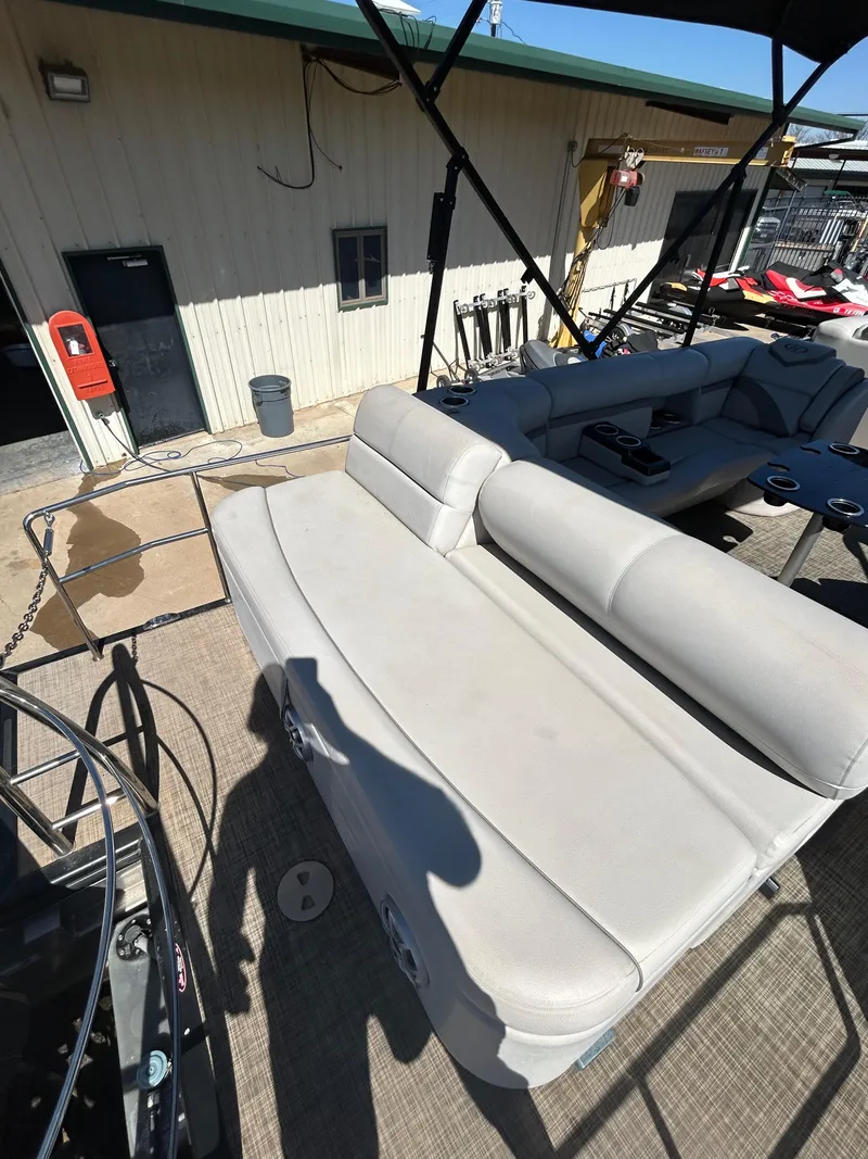Slide: The Image of 2019 Harris Sunliner 240 boat with beige seating, docked near a building. - 19