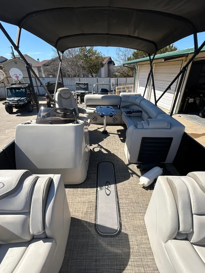 Slide: The Image of 2019 Harris Sunliner 240 pontoon boat with spacious seating and canopy in a sunny outdoor setting. - 3