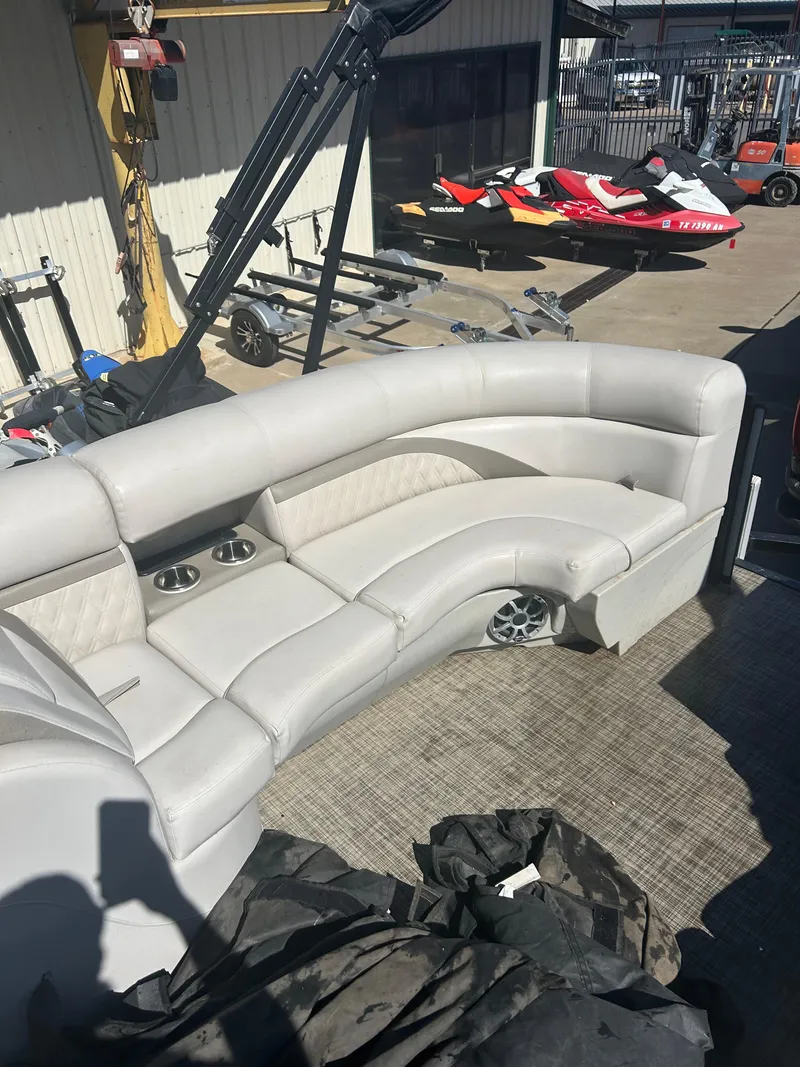 Slide: The Image of 2019 Harris Sunliner 240 boat seating with cup holders, docked near jet skis. - 30