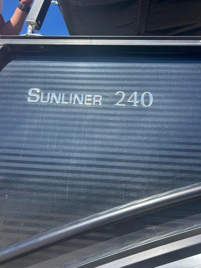 Slide: The Image of 2019 Harris Sunliner 240 boat with sleek design and metallic lettering. - 33