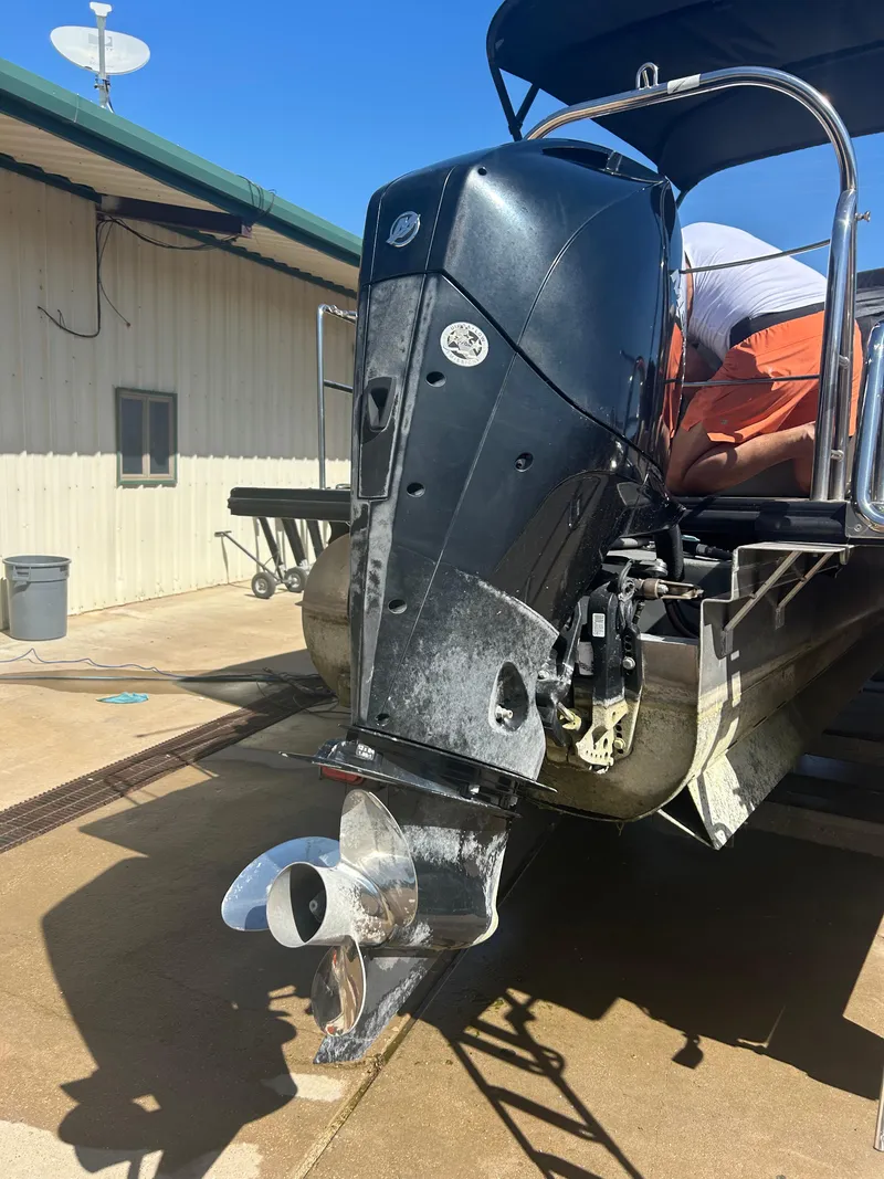 Slide: The Image of 2019 Harris Sunliner 240 boat with outboard motor, docked near a building. - 35