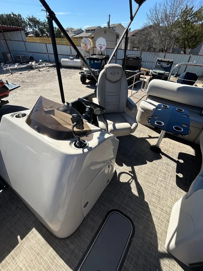 Slide: The Image of 2019 Harris Sunliner 240 boat interior with helm, seating, and cupholders. - 5