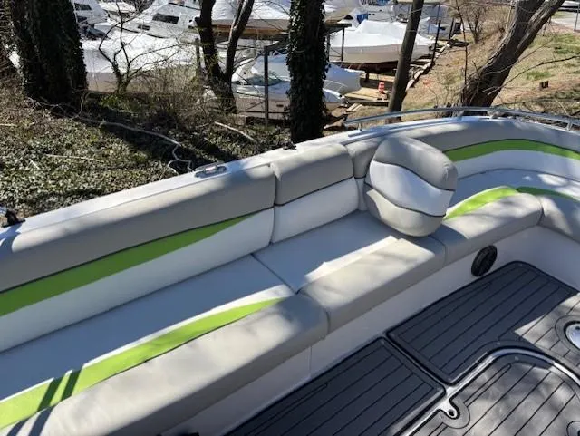 Slide: The Image of 2021 Starcraft MDX 211 E O/B boat with white and green seating, docked near trees. - 12