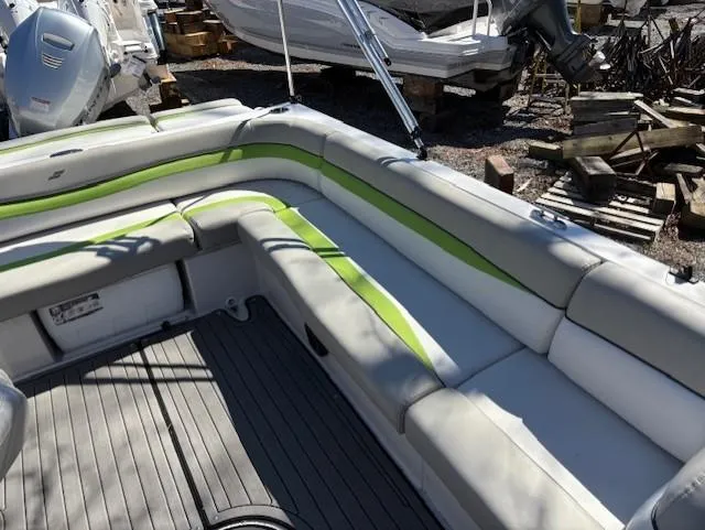 Slide: The Image of 2021 Starcraft MDX 211 E O/B boat with gray and green seating, docked outdoors. - 13