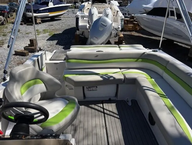 Slide: The Image of 2021 Starcraft MDX 211 E O/B boat interior with green-accented seating, docked among other boats. - 14