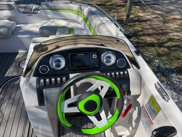 Slide: The Image of 2021 Starcraft MDX 211 E O/B boat dashboard with green-accented steering wheel and modern controls. - 15