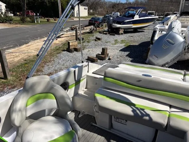 Slide: The Image of 2021 Starcraft MDX 211 E O/B boat interior with green-accented seating, parked outdoors. - 17