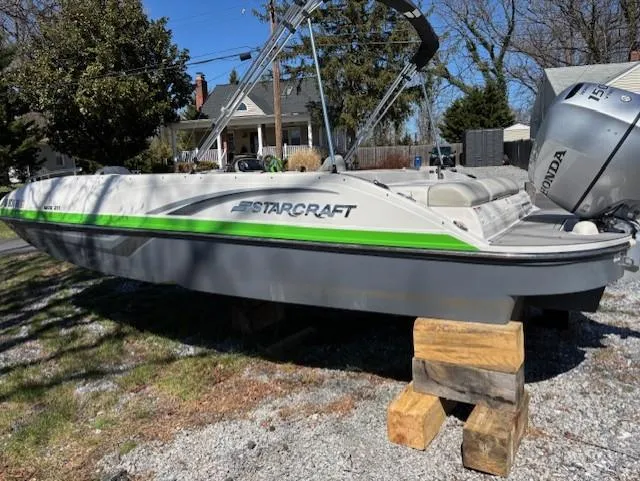 Slide: The Image of 2021 Starcraft MDX 211 E O/B boat on wooden blocks, outdoors. - 2