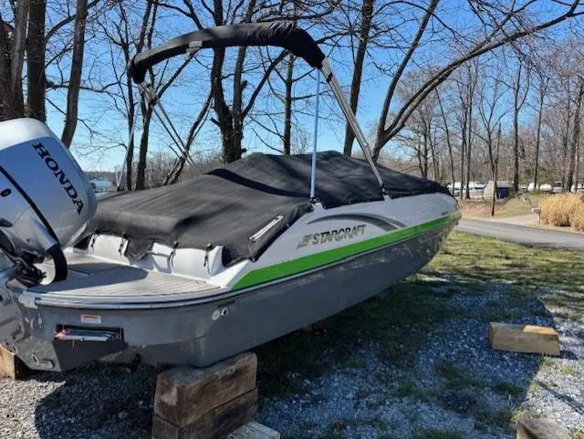 Slide: The Image of 2021 Starcraft MDX 211 E O/B boat with Honda engine, covered and parked outdoors. - 7