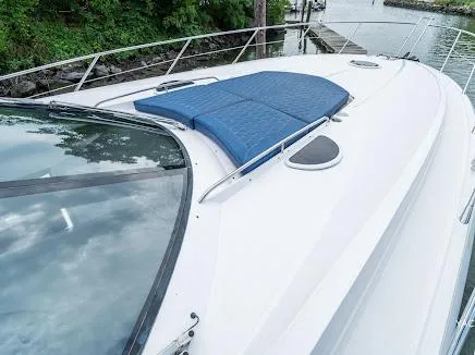 Slide: The Image of 2007 Sunseeker Predator 55 yacht with blue sun pads on deck, docked by lush greenery. - 34