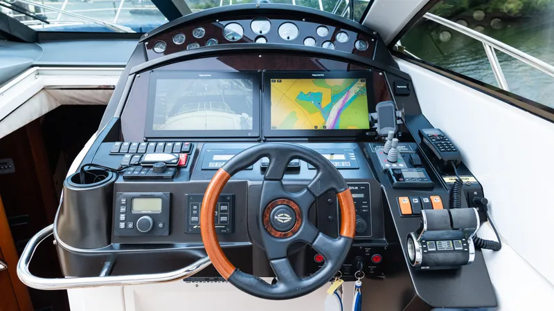 Slide: The Image of Control panel of a 2007 Sunseeker Predator 55 yacht with navigation screens and steering wheel. - 40