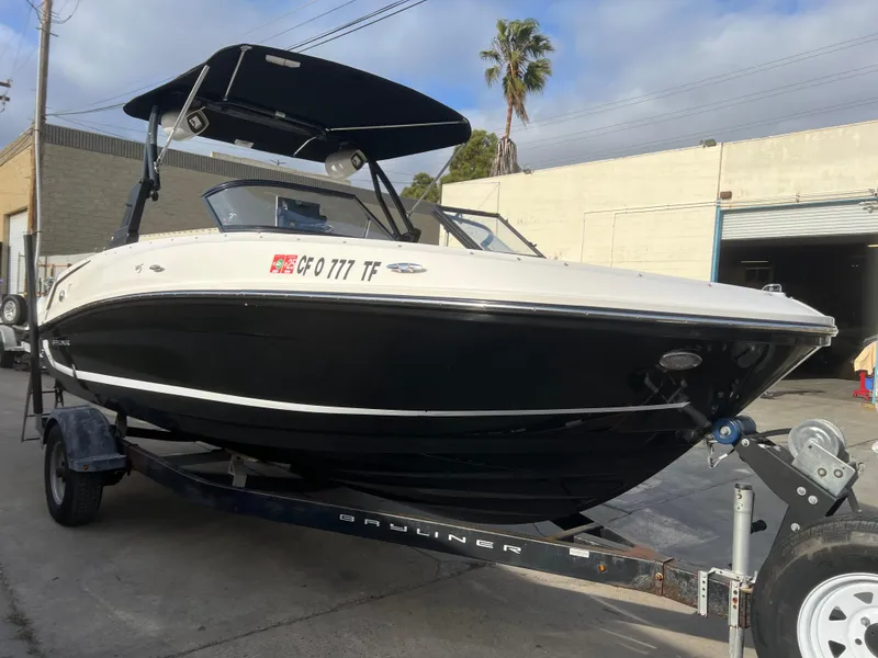 Slide: The Image of 2021 Bayliner VR5 Bowrider I/O on trailer, black hull, parked outdoors. - 2