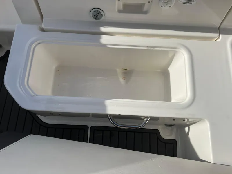 Slide: The Image of 2021 Bayliner VR5 Bowrider I/O boat storage compartment with white interior and black flooring. - 28