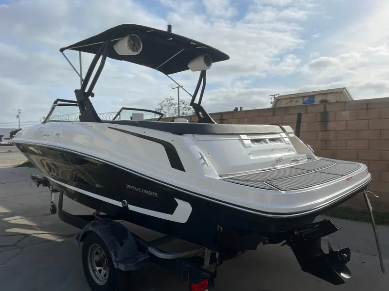Slide: The Image of 2021 Bayliner VR5 Bowrider I/O boat on trailer, black and white design, outdoor setting. - 4