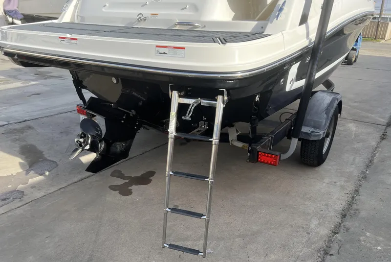 Slide: The Image of 2021 Bayliner VR5 Bowrider I/O boat with ladder and trailer, rear view. - 6