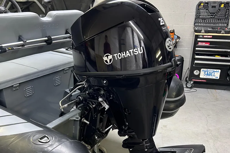 Slide: The Image of 2024 Highfield Classic 380 FCT with Tohatsu outboard motor in a garage setting. - 11
