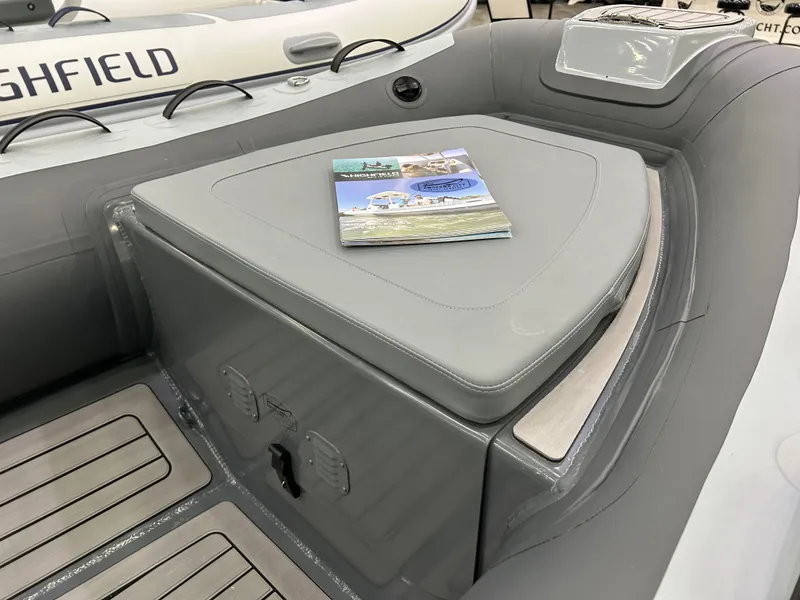 Slide: The Image of 2024 Highfield Classic 380 FCT boat interior with cushioned seating and brochure. - 6