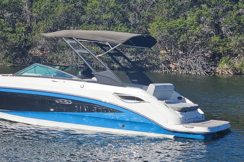 Slide: The Image of 2022 Sea Ray SDX 250 boat on a lake with lush green shoreline. - 19