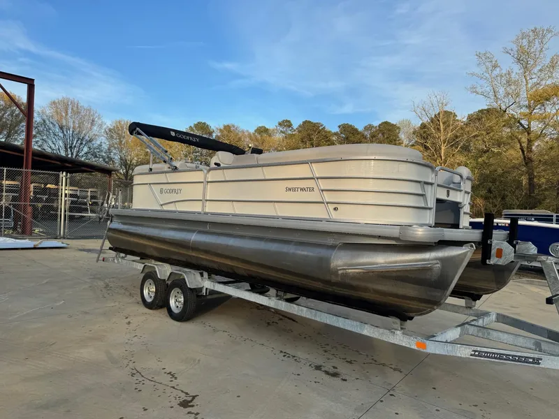 The Image of 2022 Godfrey 2286 pontoon boat on trailer, parked outdoors. - 1