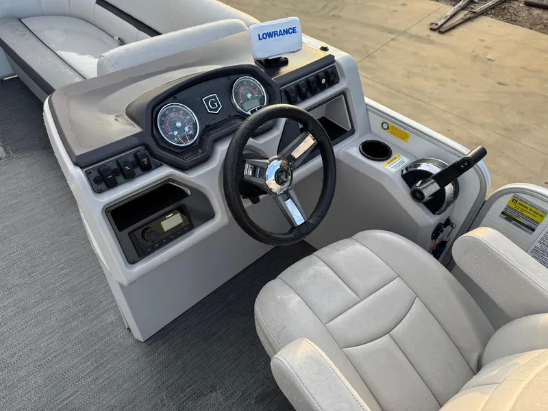 Slide: The Image of 2022 Godfrey 2286 boat dashboard with steering wheel and control panel. - 6